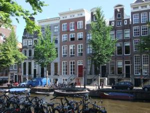 un montón de bicicletas estacionadas frente a los edificios en Residences Canal Area, en Ámsterdam