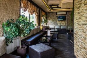 un bar con sofás y plantas en una habitación en Hi-Life Family Hotel, en Novi Iskŭr