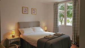 a bedroom with a bed with two towels on it at Cottages de Garrigue in Fonroque