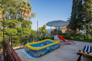 a toy pool with an umbrella on a patio at Pelivan Apartments in Kaštela