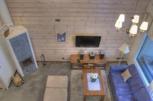 a living room with a blue couch and a tv at Kullasmarina Holiday Villas in Padasjoki