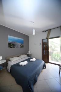 una camera da letto con un letto blu e asciugamani di Conte Agostino Pepoli a Trapani