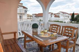 een houten tafel en stoelen op een balkon bij Apartments Villa Dolmar in Vodice