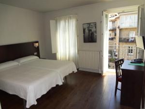 sypialnia z łóżkiem, biurkiem i oknem w obiekcie Hotel Irixo w mieście Ourense