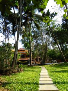 a path through a park with palm trees at Botanique Goa in Assagao