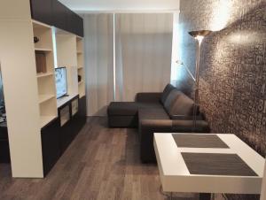 een woonkamer met een bank en een tafel bij Apartment Satama in Kuopio