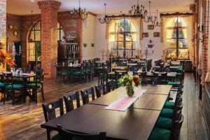 a restaurant with tables and chairs in a room at Conacul Maria Theresa in Orlat