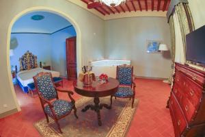 a living room with a table and chairs and a bed at Relais Villa Poschi in Pugnano