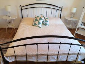 a bed with a black frame and pillows on it at Apartman Lucy in Slatine