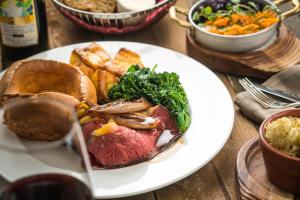 a plate of food with meat and vegetables on a table at Whatley Manor in Malmesbury