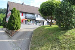 a house with a tree in front of a street at Gästehaus Mangold Fritsch in Klaus