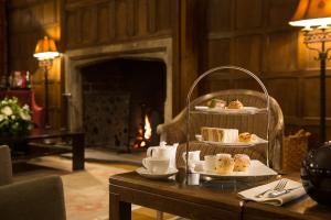 a table with a cake and pastries on a table at Whatley Manor in Malmesbury