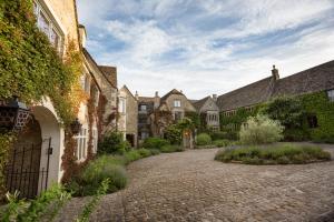 a cobblestone driveway in front of a row of houses at Whatley Manor in Malmesbury