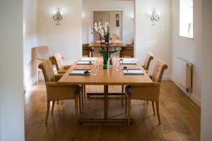 a dining room table with chairs and a vase of flowers at Whatley Manor in Malmesbury