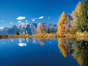 a couple standing on the edge of a lake with mountains at Apartment Zaglau in Sankt Johann im Pongau