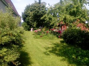 ソルタヴァラにあるGuest House Rajaの緑草・ピンクの花・木々が植えられた庭園