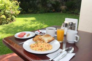 a table with plates of breakfast food on it at Paulina Youth Hostel in Oaxaca City