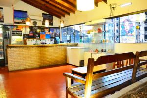 un restaurante con un banco frente a un bar en El Viajero Asuncion Hostel & Suites, en Asunción