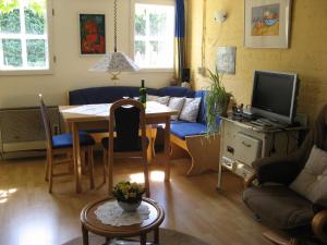 ein Wohnzimmer mit einem Tisch und einem TV in der Unterkunft 't Zwaluwennest in Exloo