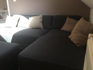 a couch with pillows on it in a room at Lumineux T2 Vieille ville 3pers parking gratuit - by La Source d'OrFée in Boulogne-sur-Mer