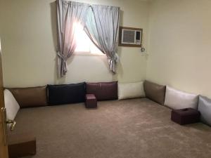 a living room with a couch and a window at شقق رفيف الشمال المخدومه - الحائط Alhayit -Rafeef Al Shamal رفيف الشمال شقق مخدومه - الحائط in Al Ḩāyiţ