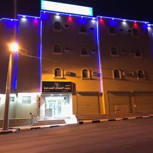 a building with blue lights on the side of it at شقق رفيف الشمال المخدومه - الحائط Alhayit -Rafeef Al Shamal رفيف الشمال شقق مخدومه - الحائط in Al Ḩāyiţ