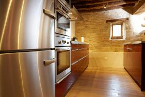 a kitchen with a stainless steel refrigerator and wooden floors at Hameau de Blagny in Puligny-Montrachet