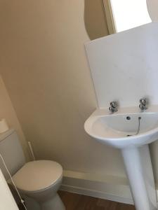 a bathroom with a white sink and a toilet at Glenfaba Guest House in Douglas