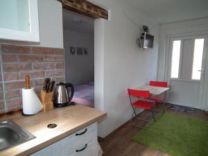 a kitchen with a sink and a room with a bed at Apartment 1 in Hrabušice