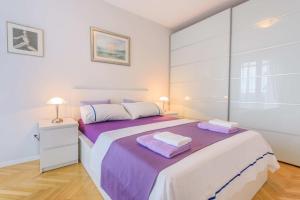 a bedroom with a large bed with purple sheets at Comfortable and Stylish Apartment in Split