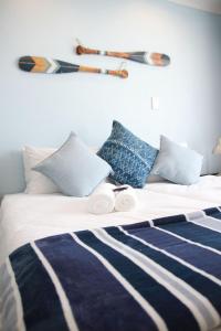 a bed with two rolled towels on top of it at Sea Wind Self Catering Cottages in Swakopmund