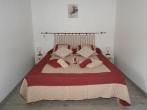 a bedroom with a bed with red and white blankets and pillows at la chomiarde in Saint-Médard-de-Presque