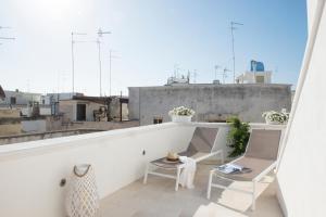 a balcony with a table and chairs on a building at Dimora Madina by MANZONI COLLECTION in Monopoli