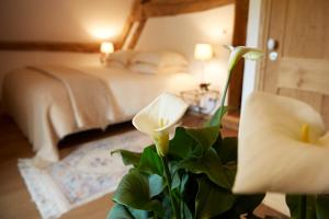 een slaapkamer met een bed en een plant op de voorgrond bij Hameau de Blagny in Puligny-Montrachet