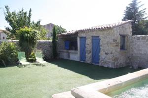 a house with two chairs and a swimming pool at Aux Pots Bleus in Nissan-lez-Enserune