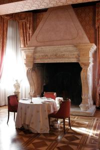 a dining room with a table and a fireplace at Park Hotel Villa Potenziani in Rieti