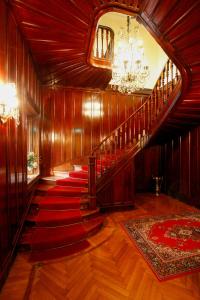 un pasillo con una escalera con alfombra roja en Park Hotel Villa Potenziani, en Rieti