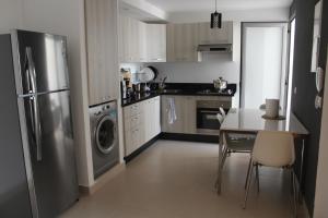a kitchen with a stainless steel refrigerator and a table at Paradise Beach in Mansouria