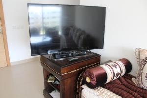 a flat screen tv sitting on top of a wooden stand at Paradise Beach in Mansouria