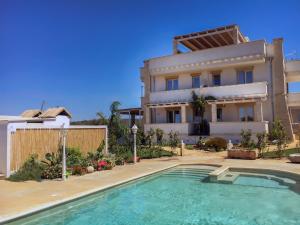 a villa with a swimming pool in front of a house at Blue and Blue in Torre San Giovanni Ugento