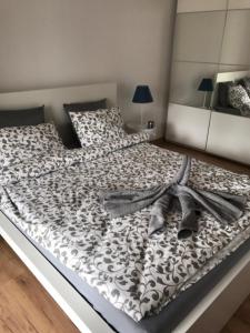 ein Bett mit einer schwarzen und weißen Bettdecke darauf in der Unterkunft OMI Apartments in Kołobrzeg