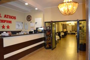 a restaurant with a counter and a dining room at Hotel Athos in Bucharest