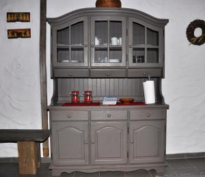 a large wooden hutch with red bowls in it at Apartma Romana in Spodnji Otok
