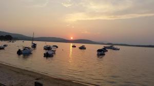 a group of boats in the water at sunset at Dasea Houses in Ormos Panagias