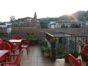 a patio with tables and chairs on a balcony at Akelarre Ostatua in Guernica y Luno +20 photos