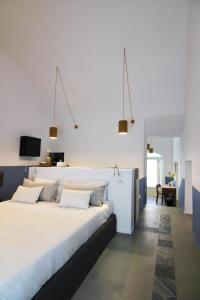 a bedroom with a large bed with white sheets and pillows at Piano Piano - Rooms in Matera