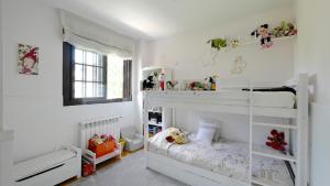 a white room with two bunk beds in it at Golf Apartment in Majadahonda