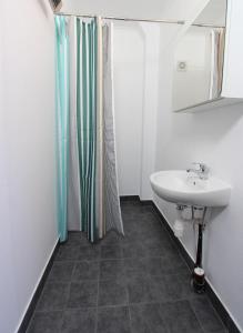 a bathroom with a sink and a shower curtain at Slottet Apartments in Tyssedal