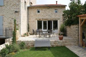 a patio with a table and chairs in front of a building at Les FREJALS in Compeyre +56 photos