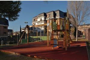 a playground with a slide in front of a building at Golf Apartment in Majadahonda